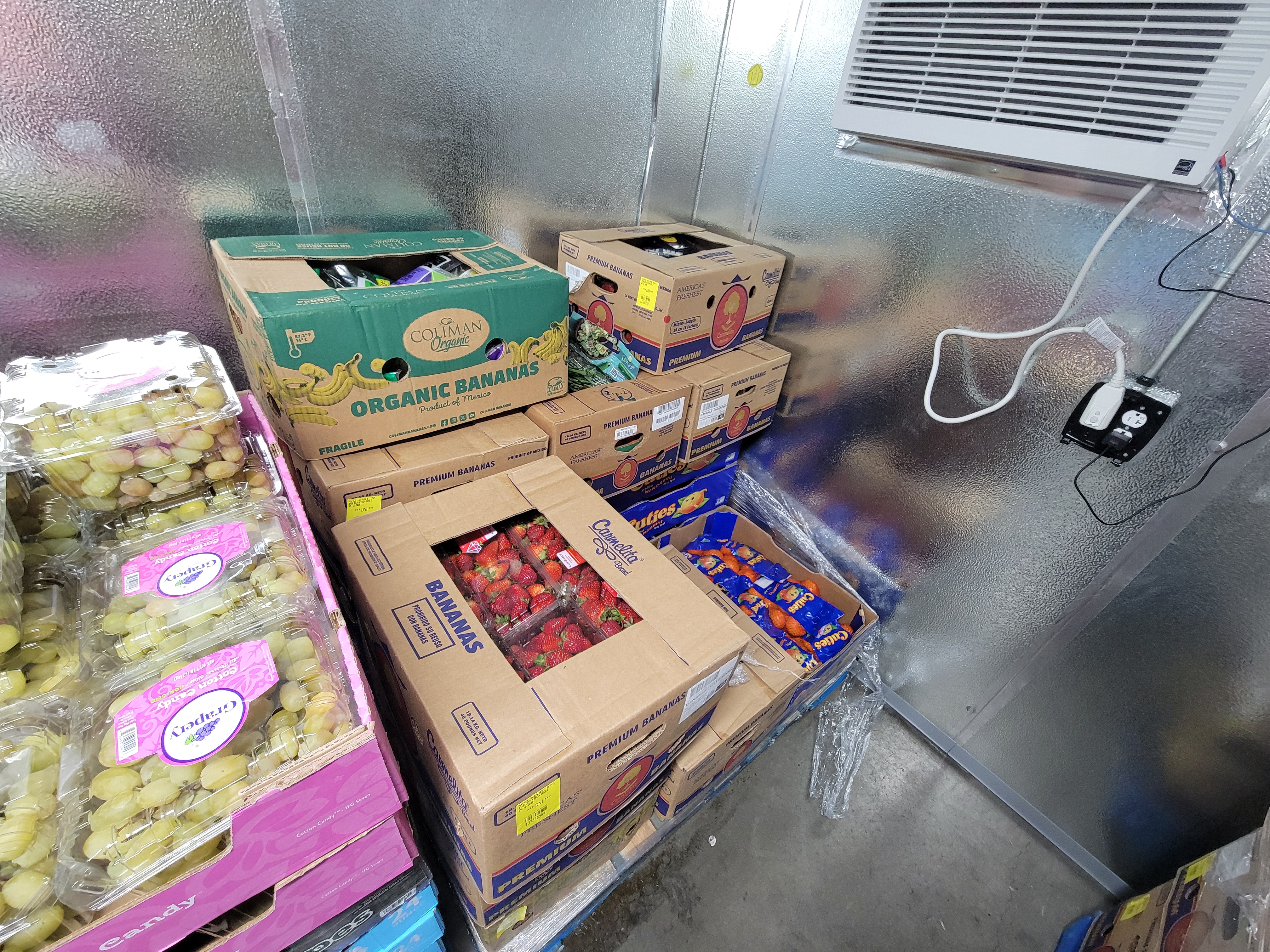 Pallets of produce in a fridge box unit.